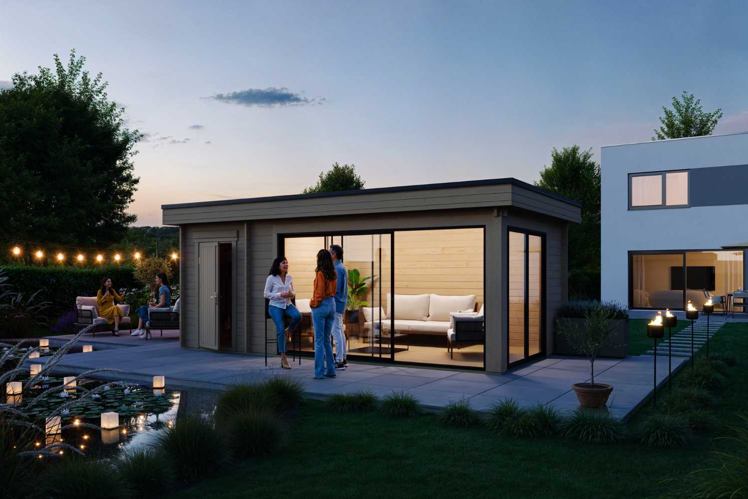 das Gartenhaus Designlounge 44 C in Abendstimmung mit einer Gartenparty davor